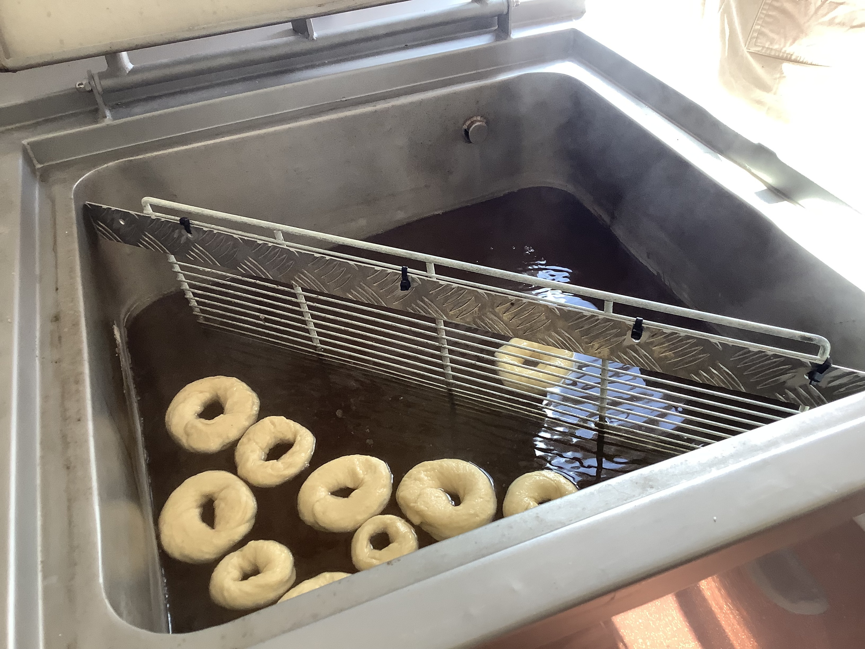 Jackie looking very excited while covering bagels in poppy seeds